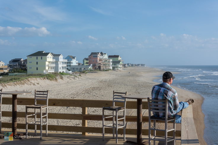 a man sits near the pier house at Rodanthe Fishing Pier